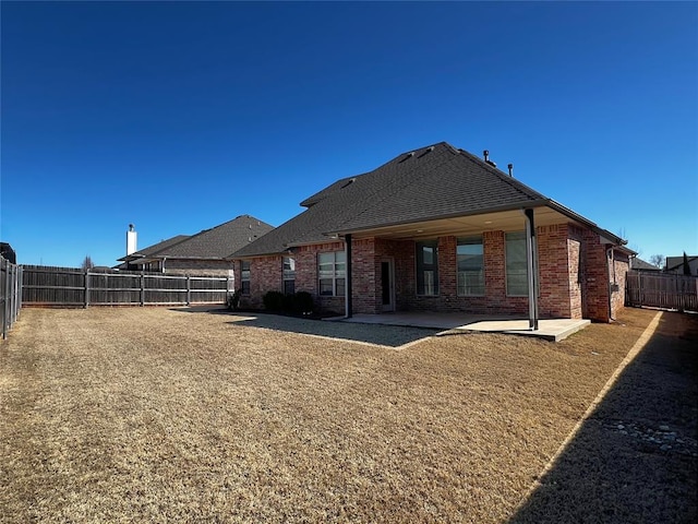 4309 NW 152nd Pl, Edmond, OK 73013 - back of property with a fenced backyard, a patio, brick siding, and roof with shingles