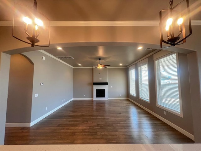 4309 NW 152nd Pl, Edmond, OK 73013 - unfurnished living room featuring dark wood-style floors, baseboards, ceiling fan with notable chandelier, visible vents, and ornamental molding