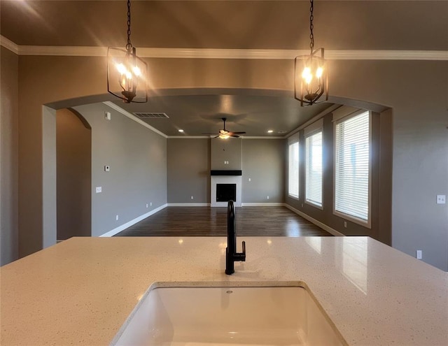 4309 NW 152nd Pl, Edmond, OK 73013 - kitchen with crown molding, ceiling fan with notable chandelier, a sink, arched walkways, and visible vents