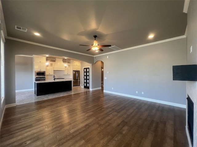 4309 NW 152nd Pl, Edmond, OK 73013 - unfurnished living room with dark wood finished floors, visible vents, arched walkways, and a ceiling fan