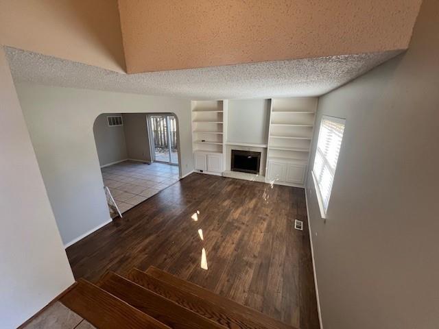 unfurnished living room featuring tile patterned flooring and a textured ceiling