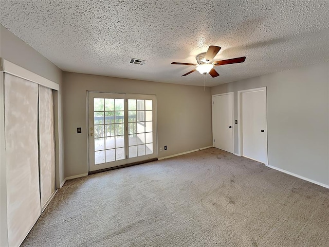 unfurnished bedroom with carpet flooring, ceiling fan, and a textured ceiling