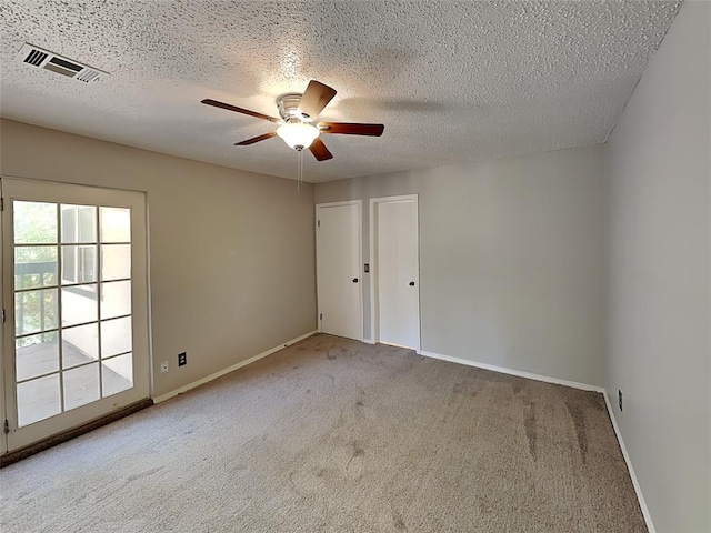 empty room with carpet flooring, a textured ceiling, and ceiling fan