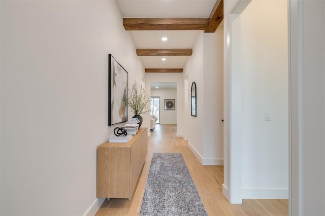 hallway featuring beam ceiling and light hardwood / wood-style floors