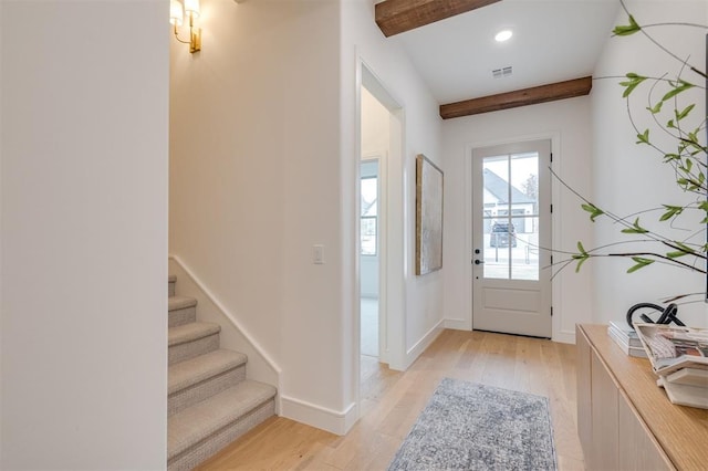 doorway with beam ceiling and light hardwood / wood-style flooring