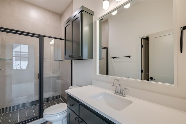 bathroom with vanity, a shower with shower door, and toilet