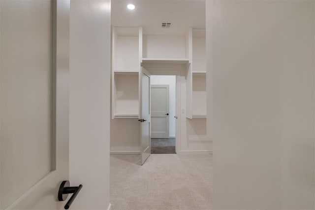 spacious closet featuring light carpet