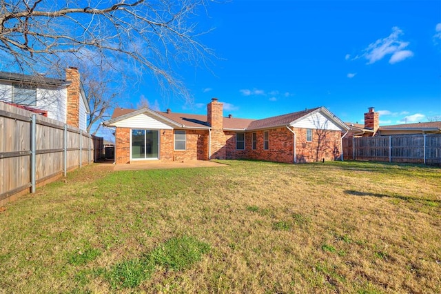 rear view of property featuring a yard and a patio area