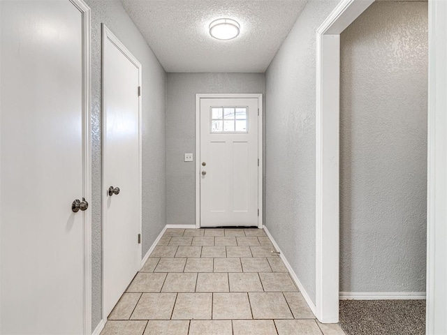 entryway featuring light tile patterned floors and a textured ceiling