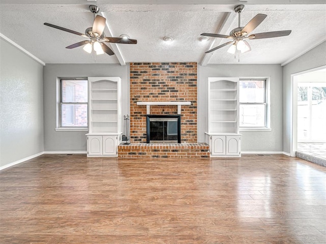 unfurnished living room with beamed ceiling, a fireplace, and a textured ceiling