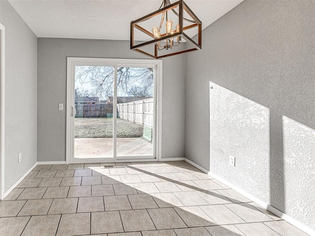 unfurnished dining area with a chandelier, a textured ceiling, and light tile patterned flooring