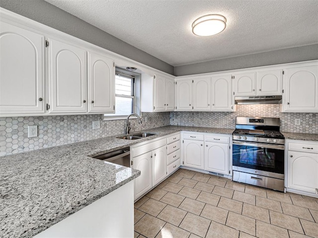 kitchen with appliances with stainless steel finishes, a textured ceiling, white cabinetry, and sink