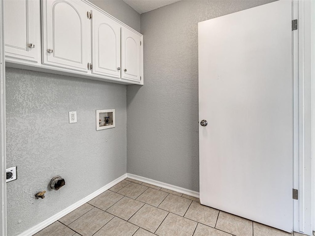 clothes washing area featuring electric dryer hookup, light tile patterned floors, cabinets, and washer hookup