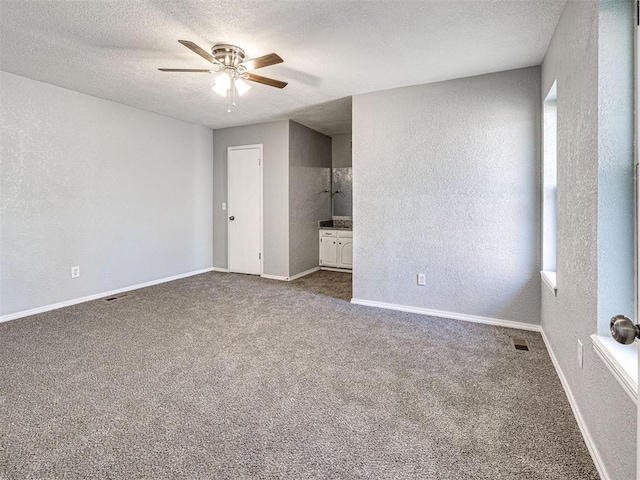 carpeted empty room featuring a textured ceiling and ceiling fan