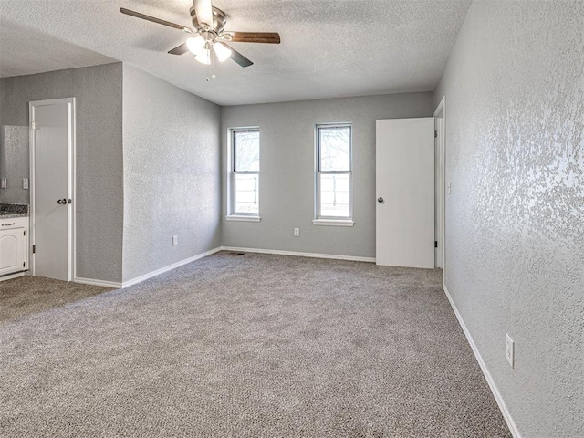 carpeted spare room with ceiling fan and a textured ceiling