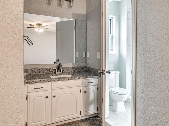 bathroom featuring ceiling fan, vanity, and toilet