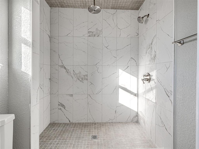 bathroom featuring toilet and tiled shower