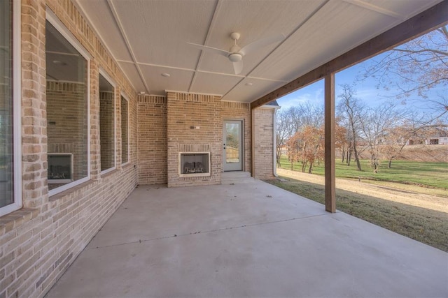 view of patio with an outdoor brick fireplace and ceiling fan