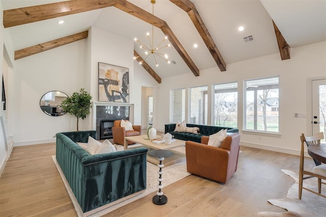 living room with a high end fireplace, light wood-type flooring, beam ceiling, high vaulted ceiling, and a notable chandelier