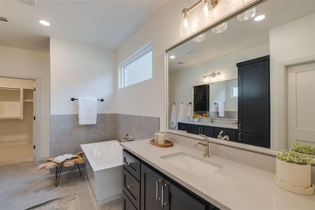 bathroom featuring vanity and a bath