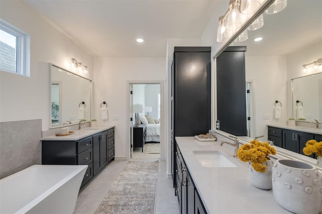 bathroom featuring a bathtub, vanity, and tile patterned flooring