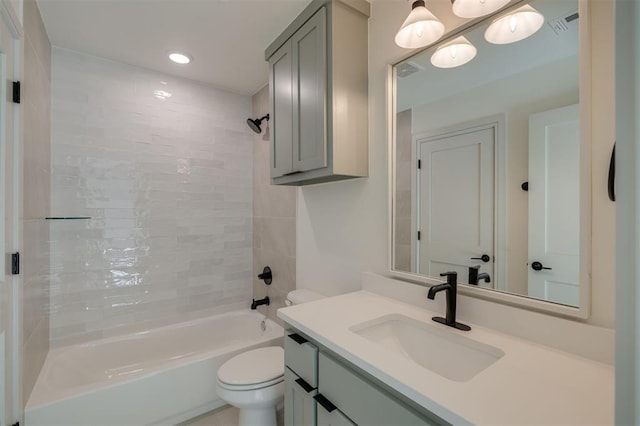 full bathroom featuring vanity, tiled shower / bath combo, and toilet