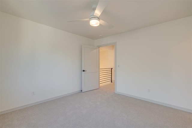 empty room with ceiling fan and light colored carpet