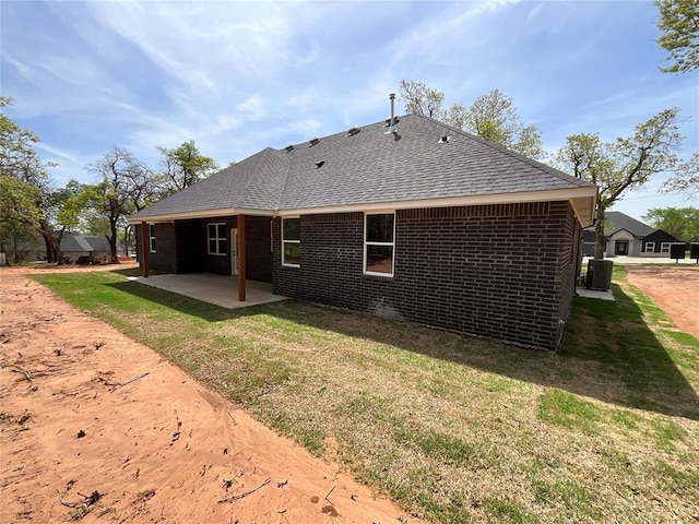2402 Black Jack Way, Blanchard, OK 73010 - back of house with roof with shingles, brick siding, central AC unit, a lawn, and a patio