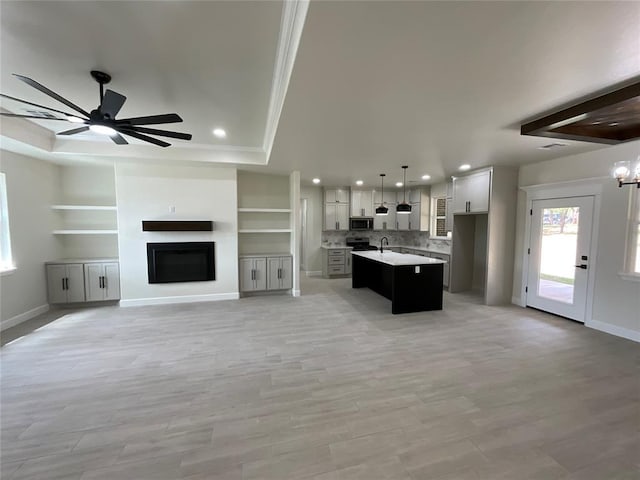 2402 Black Jack Way, Blanchard, OK 73010 - kitchen featuring recessed lighting, stainless steel microwave, open floor plan, and a raised ceiling