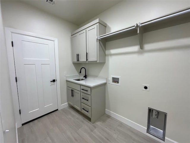 2402 Black Jack Way, Blanchard, OK 73010 - washroom with cabinet space, hookup for an electric dryer, baseboards, and light wood-style flooring