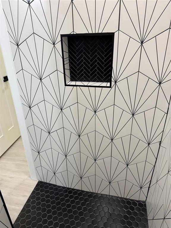 2402 Black Jack Way, Blanchard, OK 73010 - interior details with elevator, tiled shower, and wood finished floors