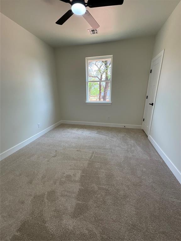 2402 Black Jack Way, Blanchard, OK 73010 - carpeted empty room with baseboards, a ceiling fan, and visible vents
