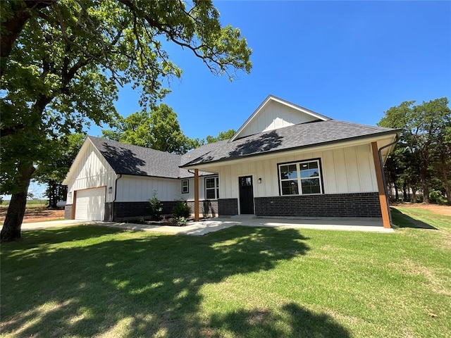 2402 Black Jack Way, Blanchard, OK 73010 - view of front of house with board and batten siding, brick siding, a shingled roof, and a front yard