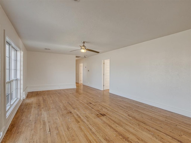 spare room with ceiling fan and light wood-type flooring