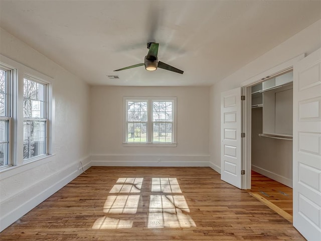2832 NW 45th St, Oklahoma City, OK 73112 - unfurnished bedroom featuring multiple windows, wood finished floors, a ceiling fan, and a closet