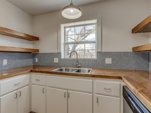 kitchen featuring decorative backsplash, sink, dishwasher, white cabinetry, and hanging light fixtures