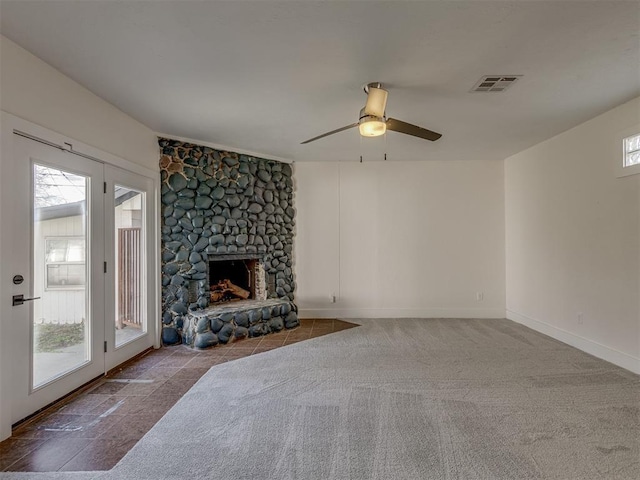 2832 NW 45th St, Oklahoma City, OK 73112 - unfurnished living room with a ceiling fan, a stone fireplace, and carpet flooring