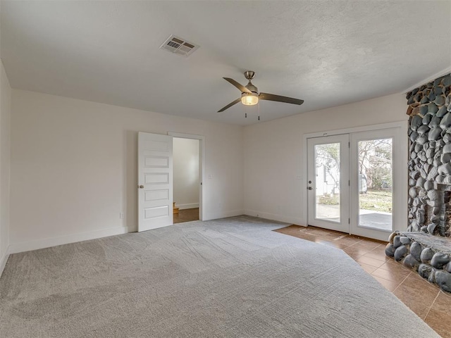 2832 NW 45th St, Oklahoma City, OK 73112 - unfurnished bedroom featuring access to outside, a fireplace, ceiling fan, tile patterned floors, and a textured ceiling