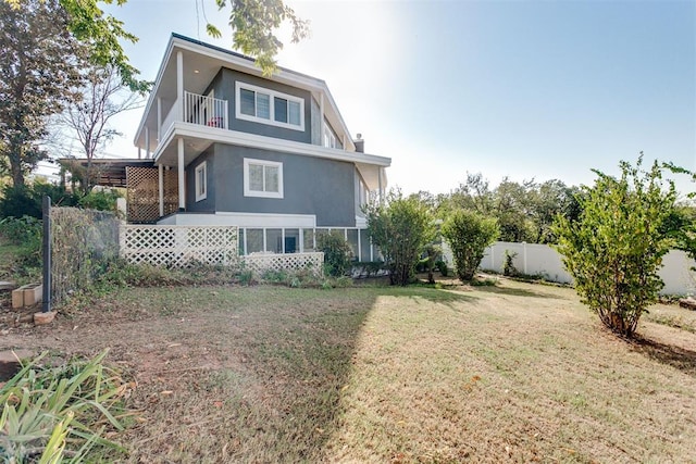 view of property exterior with a lawn and a balcony