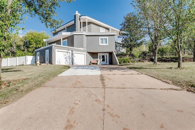 view of front of house featuring a garage and a front lawn