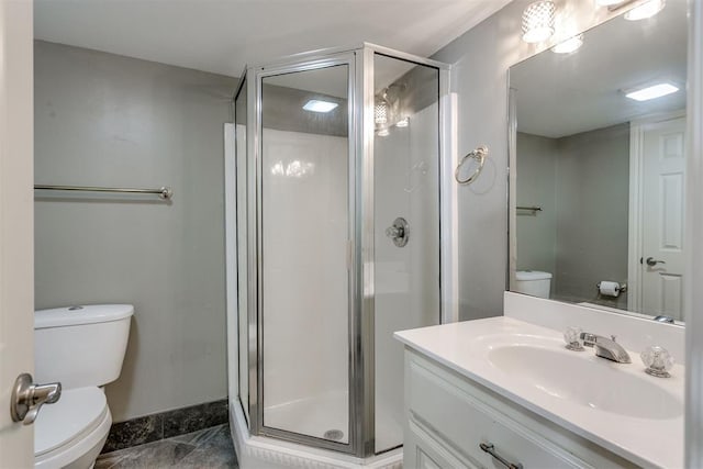 bathroom with vanity, toilet, and a shower with door