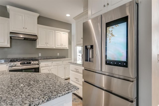 kitchen with white cabinets, appliances with stainless steel finishes, light stone counters, and range hood