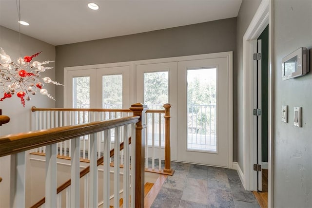 doorway to outside featuring an inviting chandelier