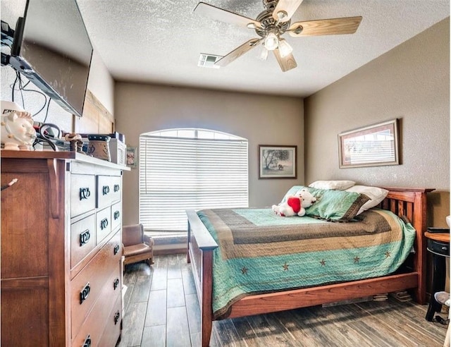 bedroom featuring ceiling fan, wood-type flooring, and a textured ceiling