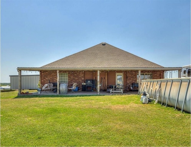 rear view of property featuring a yard and a patio