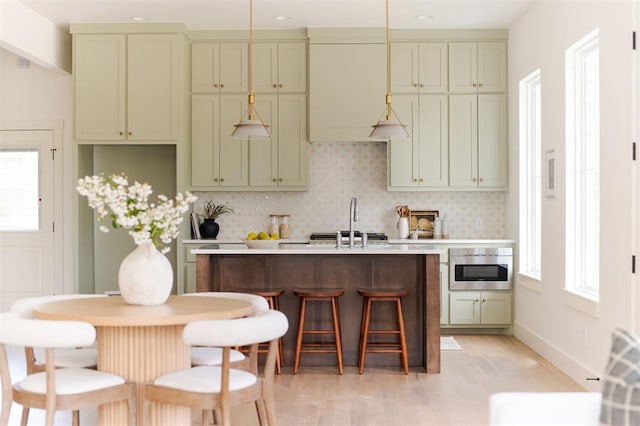 kitchen featuring tasteful backsplash, a breakfast bar, and decorative light fixtures