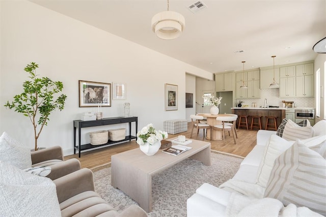 living room with light wood-style floors and visible vents