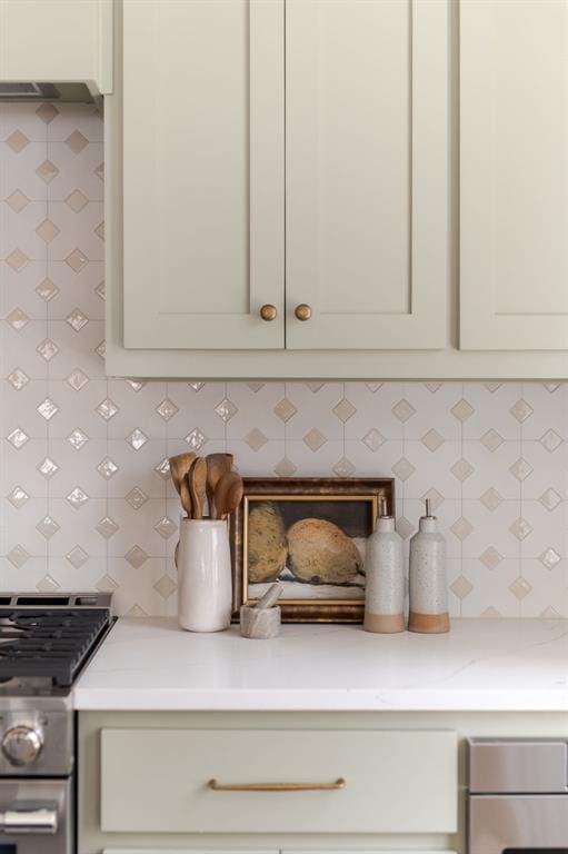 room details featuring stainless steel gas stove, tasteful backsplash, and light countertops