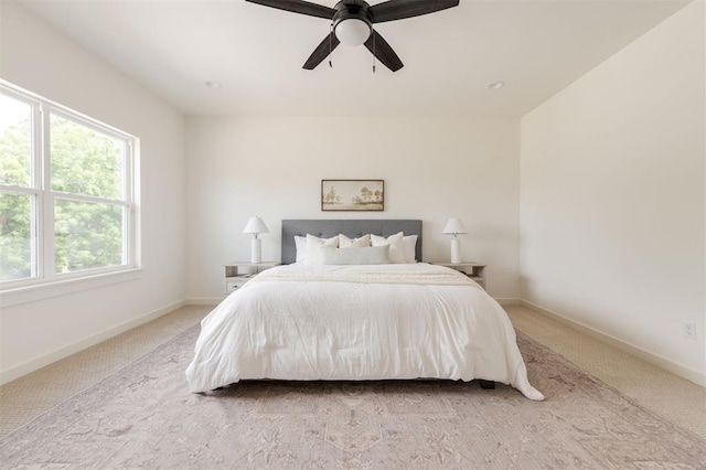 bedroom featuring ceiling fan, baseboards, and light carpet