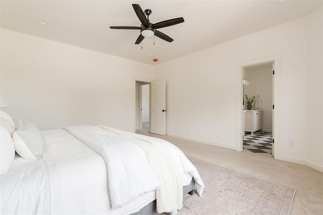 bedroom with light carpet, ceiling fan, ensuite bathroom, and baseboards